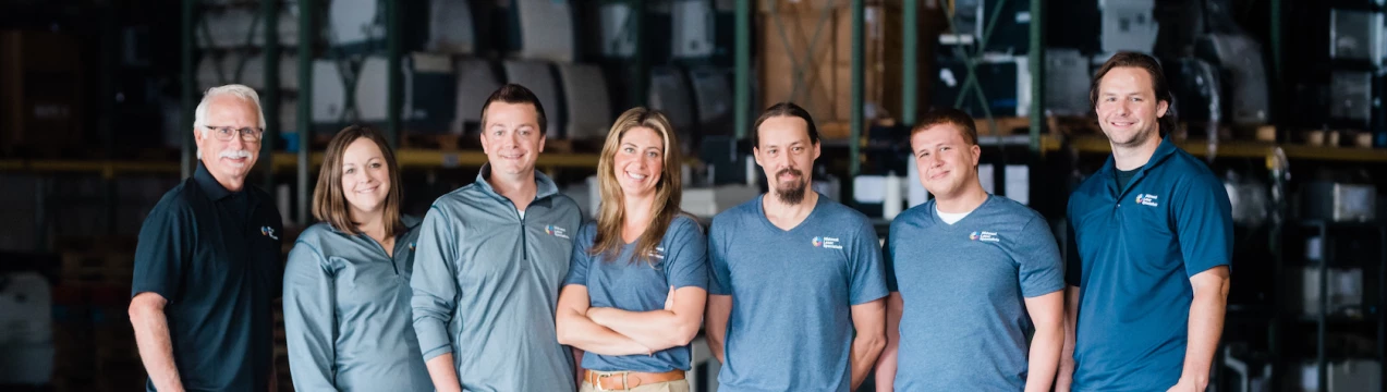 A group of employees at Midwest Laser Specialists posing for a picture in a warehouse